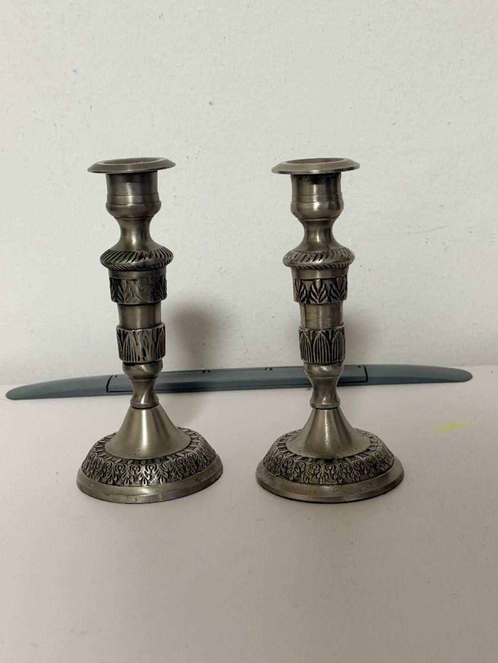 metal candlestick holders featuring detailed leaf and geometric embossed pattern